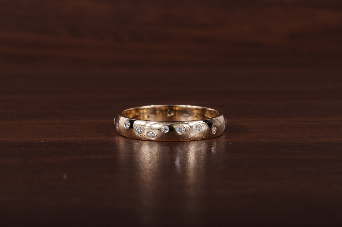 A gold band ring with a row of small clear stones