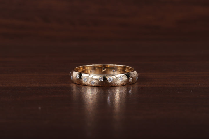 A gold band ring with a row of small clear stones