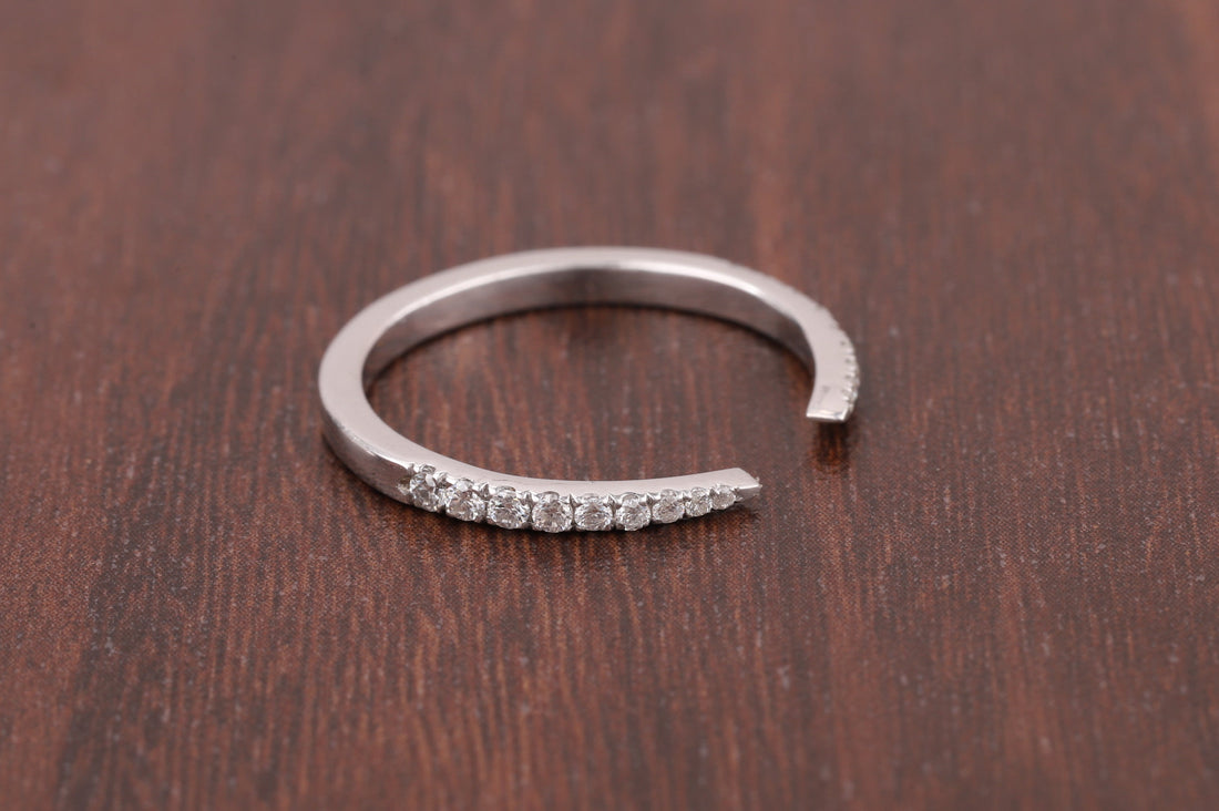 Silver open ring with small diamonds on a wooden surface